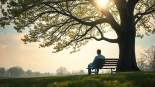 A person reflects on dealing with grief in a serene park setting, surrounded by nature.