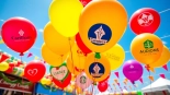 Print balloons with your logo displayed in a lively outdoor celebration setting.