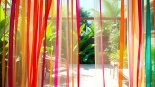 Descubre las cortinas hawaianas coloridas que dividen el espacio en un ambiente tropical.